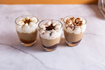 Assortment of mini chocolate and nuts desserts in the glass. Mini choloate desserts on a white background