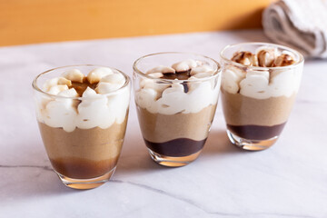 Assortment of mini chocolate and nuts desserts in the glass. Mini choloate desserts on a white background