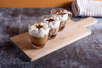 Assortment of mini chocolate and nuts desserts in the glass. Mini choloate desserts on a rustic background