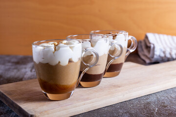 Assortment of mini chocolate and nuts desserts in the glass. Mini choloate desserts on a rustic background