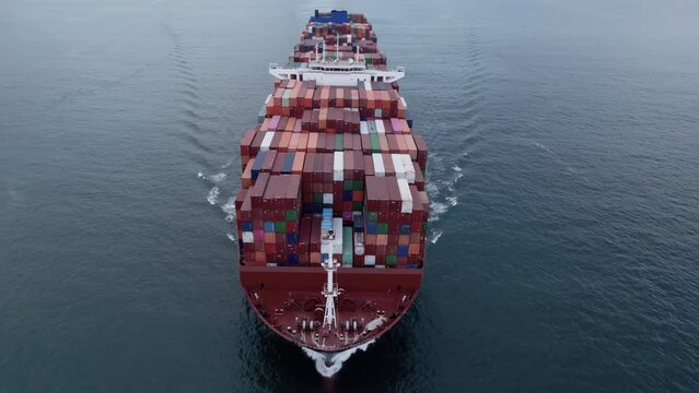 Aerial top view of international containers cargo ship in open ocean. Logistics, import and export concept.