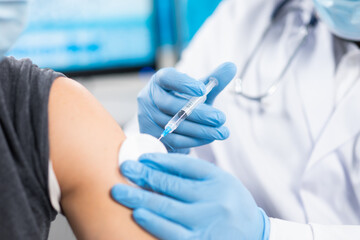 African-American doctor makes a coronavirus vaccine using a syringe and hypodermic needle....