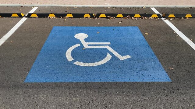 Disabled people sign painted on asphalt for parking.