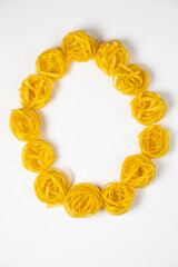 few homemade fettuccine nest in the shape of the letter O isolated on white background