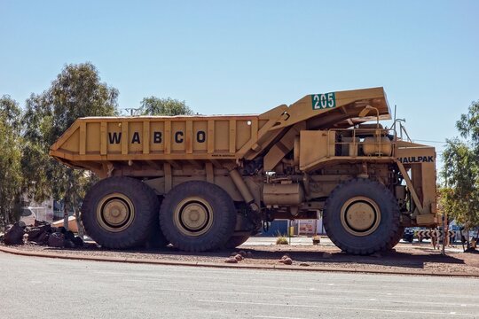 Large yellow Wabco Haulpak truck in Newman, Western Australia in noon shadow