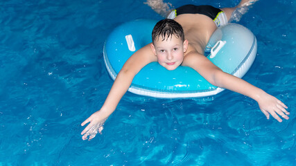 A smiling boy is bathing in the water. Sports and recreation. Healthy lifestyle