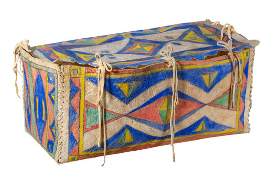 Indian painted rawhide box with leather cords isolated on white