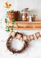 Easter decoration mood home interior - wooden shelf with wreath, Easter garland, egg jar and home flower