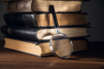A magnifying glass on a stack of books