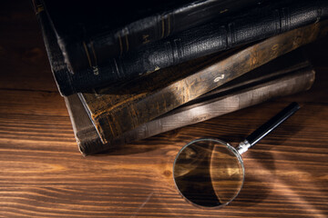 A magnifying glass on a stack of books