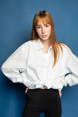 Tender girl with red hair and white skin isolated on blue in blouse