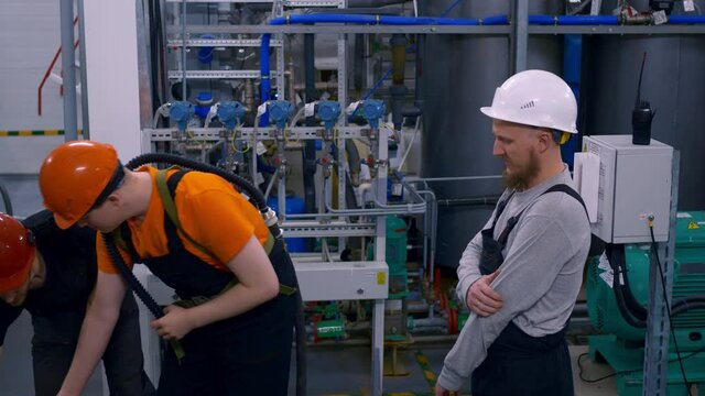 Three Different Male Heavy Industry Engineers And Uniformed Workers Stand In A Petrochemical Plant Wearing A Breathing Mask. An Industrial Contractor Uses A Breathing Mask In A Gassed Area