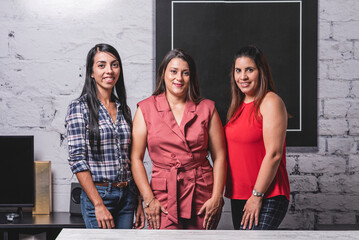 Retrato horizontal tres mujeres latinas profesionales viendo a cámara	