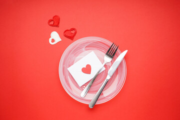 Stylish table setting and gift for Valentine's Day on a red background, flat lay.