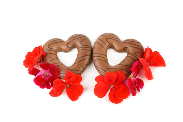 Chocolate cookies in the shape of hearts and bright flowers isolated on white . Valentine's Day pattern.