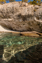 large white stones in azure water against the background of rocks