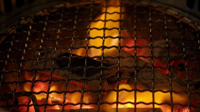 Fire in BBQ Charcoal grill stove for grilling food with smoke hood. It is commonly used in grill restaurants. Found in Asian food such as Korean Japanese and Chinese restaurants. Charcoal stove flames