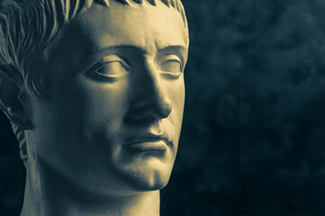 Bronze color gypsum copy of ancient statue of Germanicus Julius Caesar head for artists on dark...
