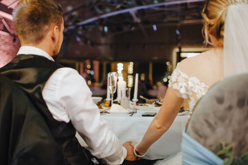 loving couple of newlyweds tenderly hold hands, close-up