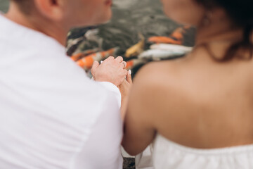 loving couple of newlyweds tenderly hold hands, close-up