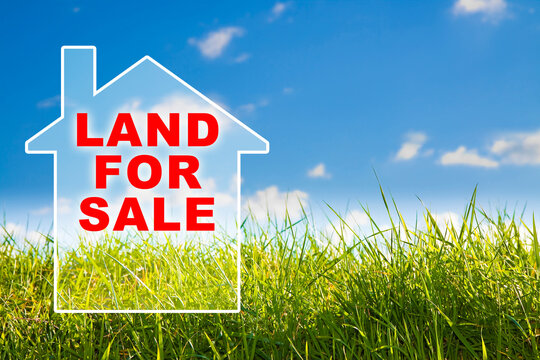 Vacant Land for Sale text in a rural scene over a small home background - Real Estate concept with green wild grass on sky background