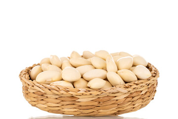 Lots of organic white beans in a straw plate, macro, isolated on white.