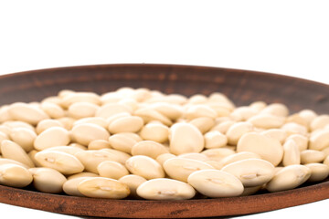 Lots of organic white beans on a clay dish, macro, isolated on white.