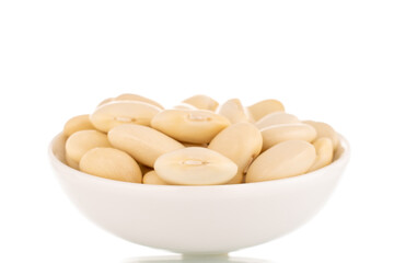 Lots of organic white beans in a white saucer, close-up, isolated on white.