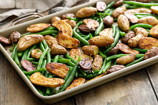Roasted crispy fingerling potatoes with green beans on a sheet pan