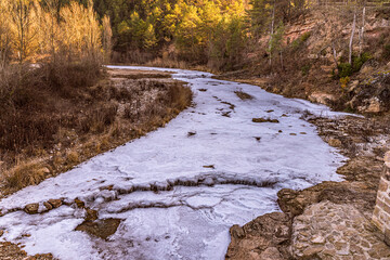 Paisatge gelat a la ribera salada al seu pas pel pont medieval, al petit poble lleidatà d'Ogern .