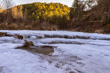 Paisatge gelat a la ribera salada al seu pas pel pont medieval, al petit poble lleidatà d'Ogern .