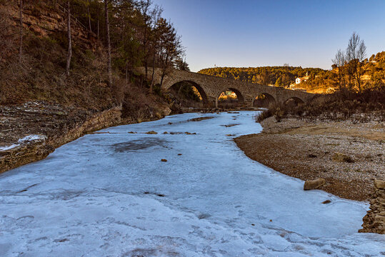 Paisatge gelat a la ribera salada al seu pas pel pont medieval, al petit poble lleidat&agrave; d'Ogern .