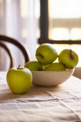 Apple fruit into the ceramic bowl on terrace table at the morning with sunlight