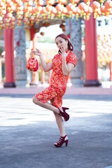 Asian Chinese woman in cheongsam dress holding shopping bags. Happy Chinese New Year