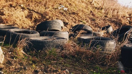 Used Worn Out Rubber Car Tires Dumped Illegally on Public Field	