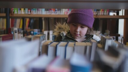 Young Intelligent Smart Caucasian Girl Looking For Interesting Book to Read in Public Library	