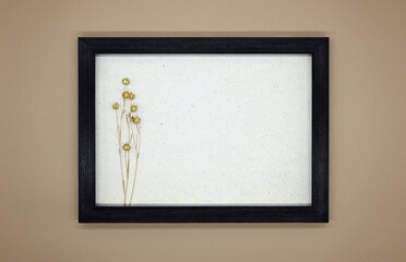 Mockup, wooden frame on a beige background. Inside the frame is dry flax with seed pods. The effect of a three-dimensional picture. Flat lay, top view, copy space, eco concept.