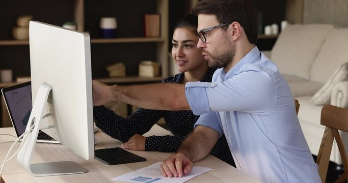 Two business person working in office, look at computer screens discussing market growth, checking global currency fund exchange. Stock traders analyse stats, dynamic shown on graphs, trading concept