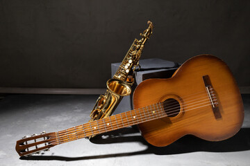 Acoustic guitar and saxophone in studio. Music concept with musical instrument - obrazy, fototapety, plakaty