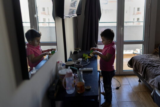 Huzhabr Royeen, 5, plays in a hotel room in Athens