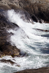Waves crashing against the stone in the sunlight