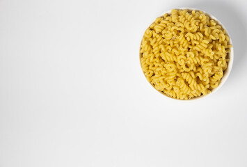 Raw Cavatappi Cellentani pasta in a plate isolated on yellow background top view
