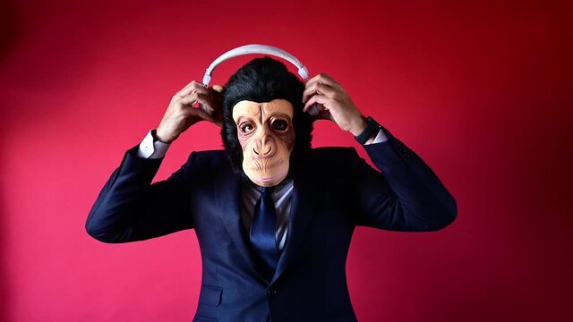 Businessman with monkey mask looking at camera