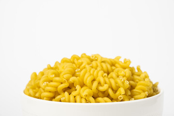 Raw Cavatappi Cellentani pasta in a plate isolated on yellow background
