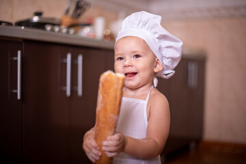 
child with bread in his hands dressed as a cook