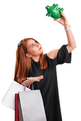 Redhead girl holding shopping bags and an empty piggy bank