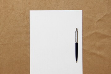 Template of white paper with pen lies on light brown cloth background. Concept of business plan and strategy. Stock photo with empty space for text and design