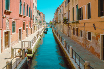 Fototapeta na wymiar Typical Venetian street with narrow canal, boats on, summer
