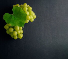 Bunches of grapes on dark wood background. Flat lay. Variety of ripe colorful grapes as the symbol...