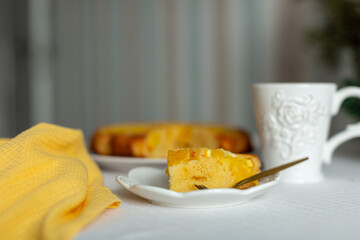 A piece of orange pie on a white plate on the table